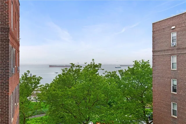 a view of a building next to a big yard and large trees