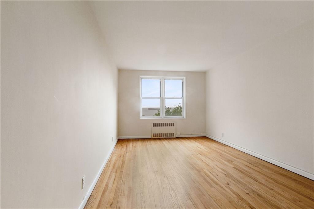 6801 Shore Road, Unit 5U Brooklyn, NY 11220 - Photo 5 of 21 an empty room with wooden floor and windows