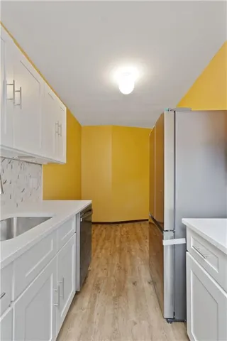 a view of a hallway with wooden floor and a window
