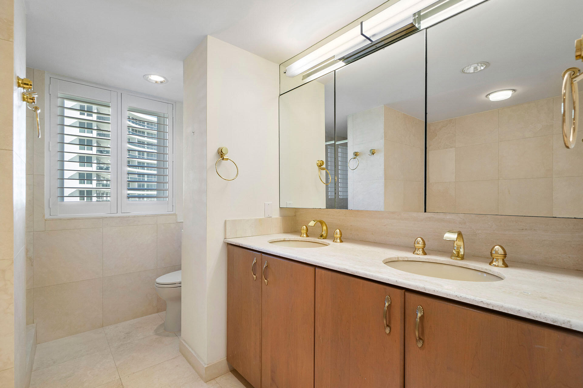 750 South Ocean Boulevard, Unit 5N Boca Raton, FL 33432 - Photo 21 of 30 a bathroom with a granite countertop sink a toilet and a mirror