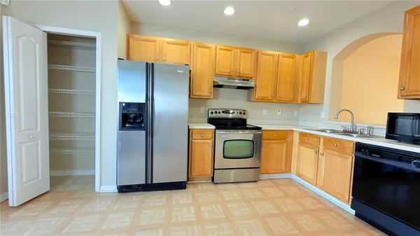 a kitchen with stainless steel appliances a refrigerator sink and cabinets