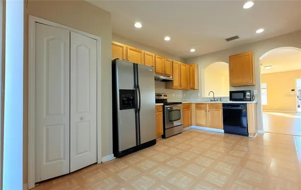 a kitchen with a refrigerator a sink and cabinets