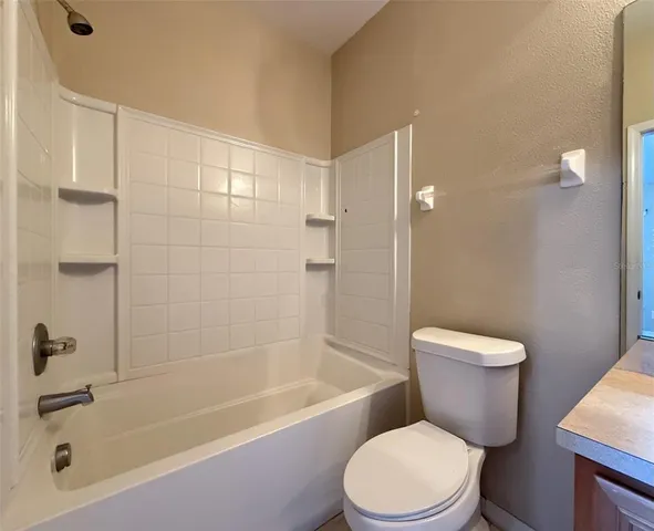a white toilet and tub sitting next to a bathroom sink
