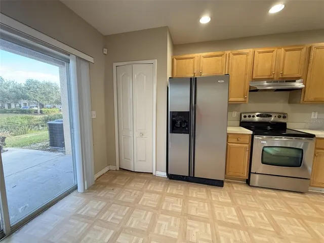 a kitchen with stainless steel appliances granite countertop a stove a refrigerator and a sink