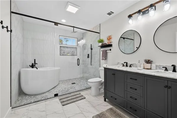 a kitchen with stainless steel appliances granite countertop a refrigerator a sink a stove and white cabinets with wooden floor