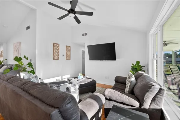 a living room with furniture and a view of kitchen