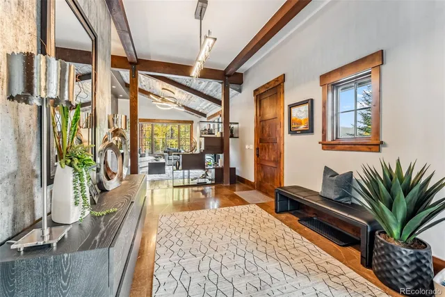 a living room with furniture large window and wooden floor