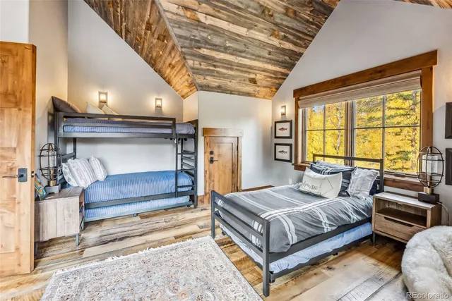 a bedroom with a bed and a dresser next to a window