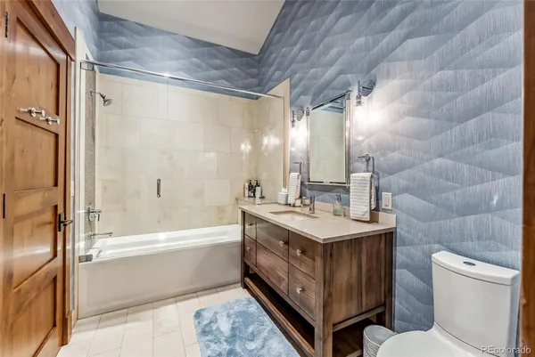 a bathroom with a double vanity sink toilet mirror and bathtub
