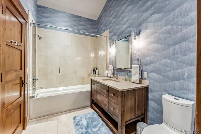 a bathroom with a double vanity sink toilet mirror and bathtub