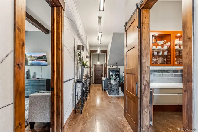 a view of a hallway with wooden floor and a bathroom