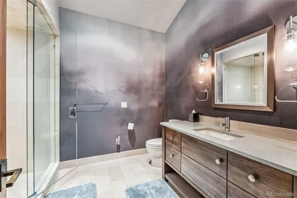 a bathroom with a double vanity sink toilet and shower