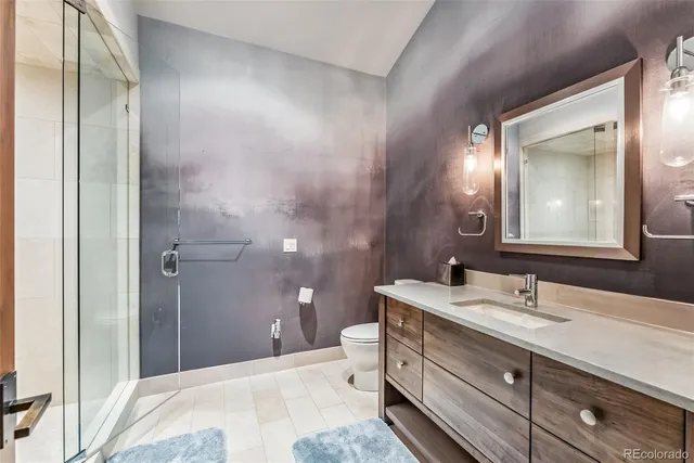 a bathroom with a double vanity sink toilet and shower