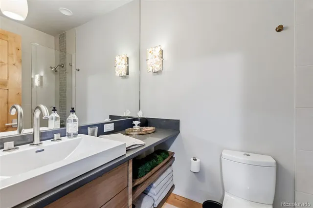 a bathroom with a sink a toilet and a mirror