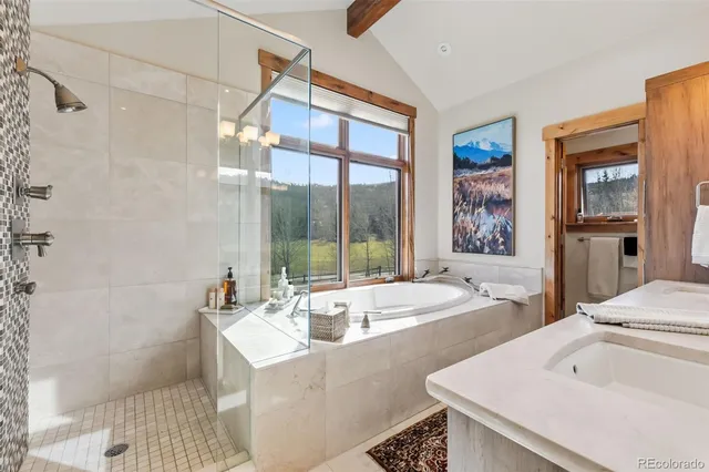 a bathroom with a tub sink and mirror