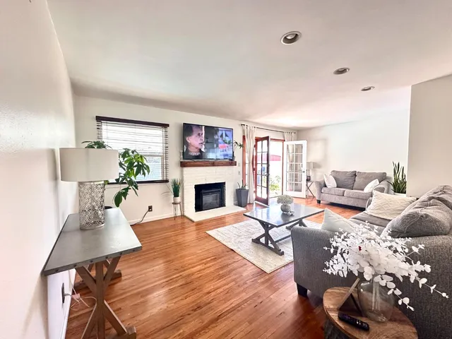 a living room with furniture fireplace and a large window