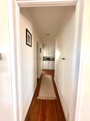 a view of a hallway with wooden floor