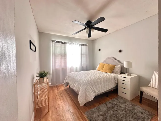 a bedroom with a bed chandelier and a window