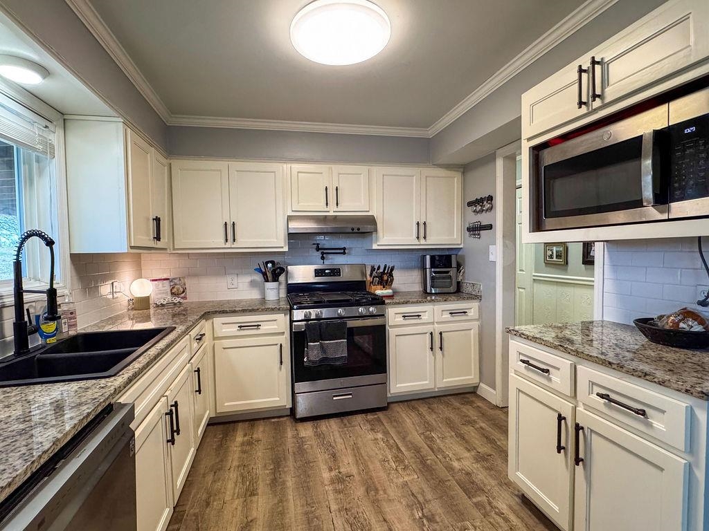 127 Walton Loop Covington, TN 38019 - Photo 12 of 40 a kitchen with granite countertop cabinets stainless steel appliances and a sink