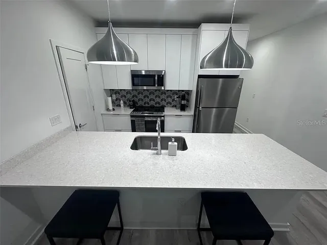 a kitchen with a sink a counter space and cabinets