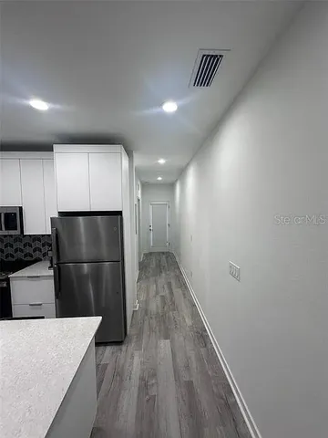 a kitchen with a refrigerator and a stove top oven