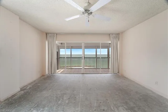 an empty room with a ceiling fan and a window