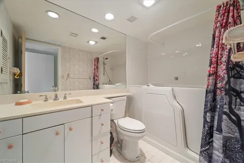 a bathroom with a double vanity sink and mirror with shower