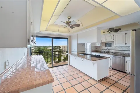 a kitchen with stainless steel appliances granite countertop a sink a stove and a wooden cabinets