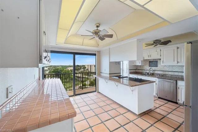 a kitchen with stainless steel appliances granite countertop a sink a stove and a wooden cabinets