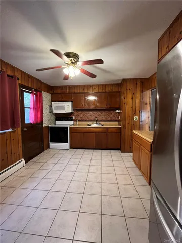 a kitchen with granite countertop a refrigerator and a stove top oven