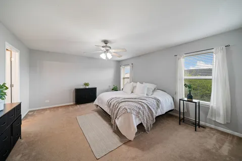 a spacious bedroom with a bed and a chandelier