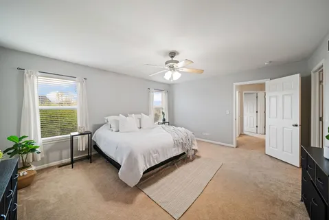 a spacious bedroom with a bed and a chandelier