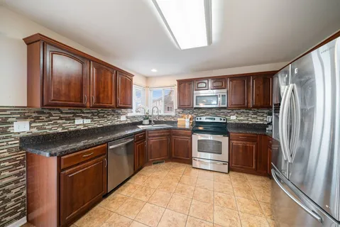 a kitchen with stainless steel appliances granite countertop a refrigerator stove and sink