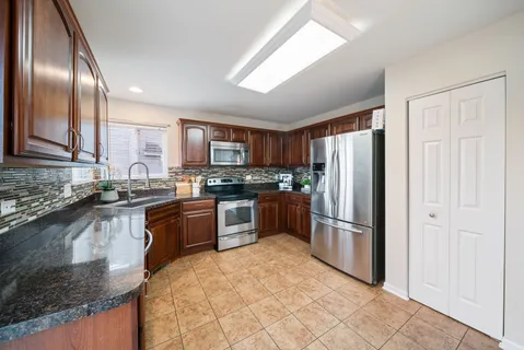 a kitchen with granite countertop stainless steel appliances and wooden cabinets