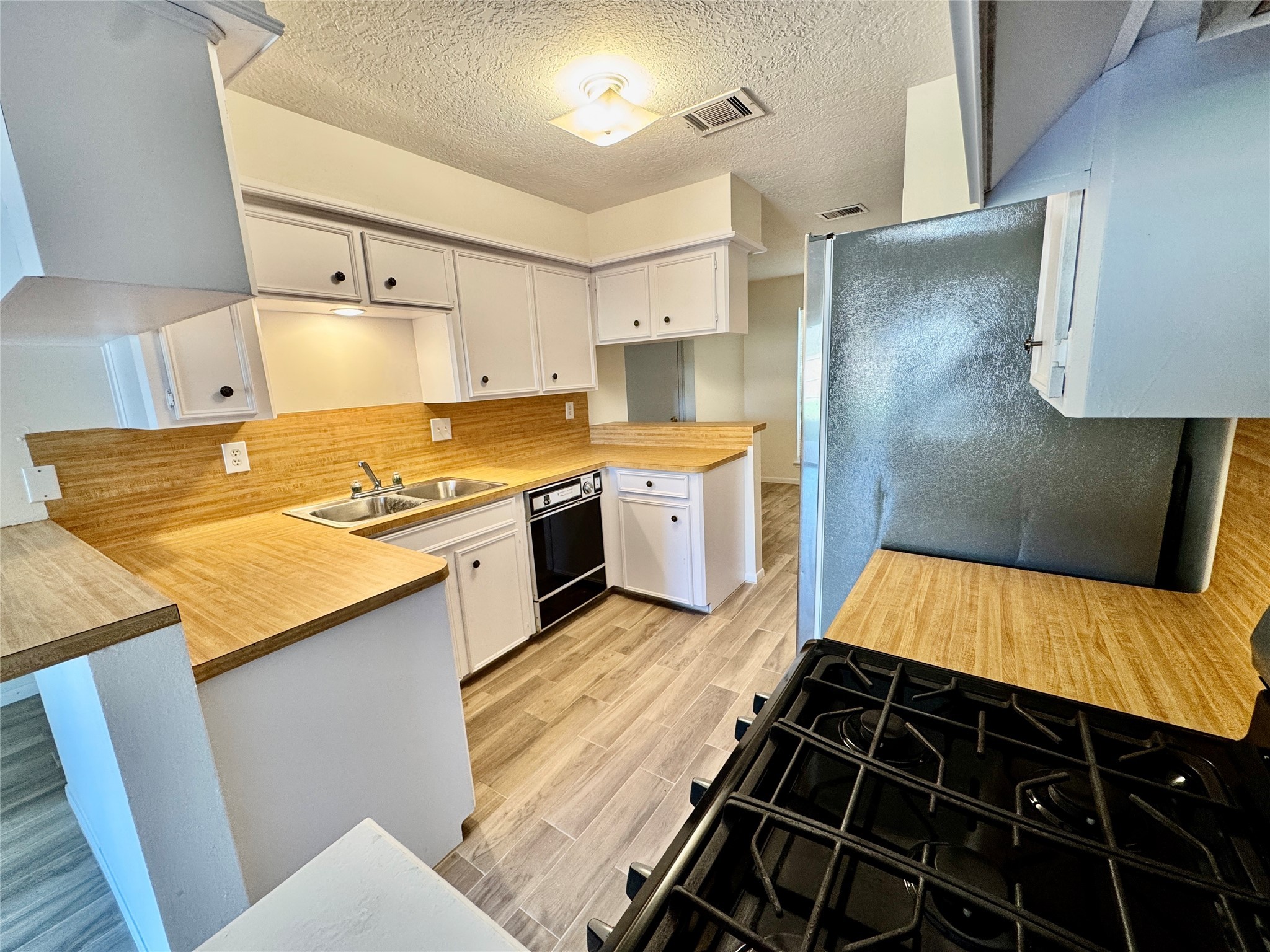 22306 Waynoka Road Katy, TX 77450 - Photo 8 of 21 a kitchen with granite countertop a stove and white cabinets