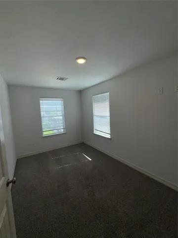 en empty room with windows and ceiling fan
