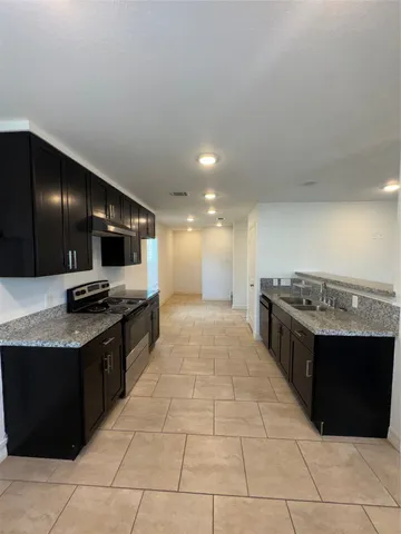 a kitchen with stainless steel appliances kitchen island granite countertop a sink and cabinets