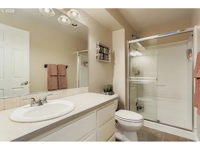 a bathroom with a sink toilet vanity and shower