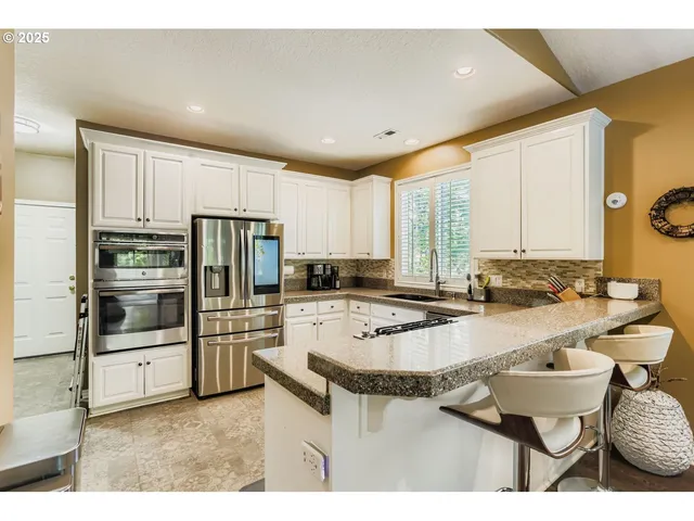a kitchen with granite countertop a sink stove and refrigerator