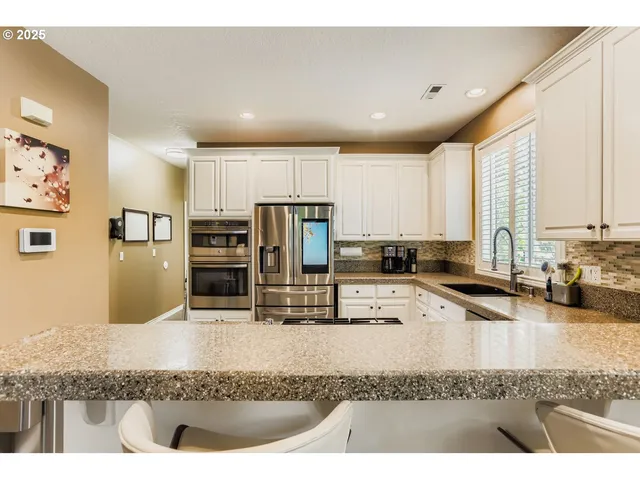 a kitchen with stainless steel appliances kitchen island granite countertop a sink and counter space