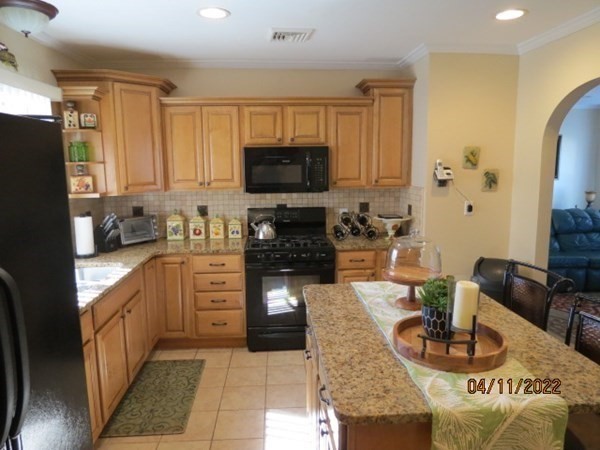 312 America Street Fall River, MA 02721 - Photo 6 of 26 a kitchen with stainless steel appliances granite countertop a refrigerator a stove top oven a sink and cabinets