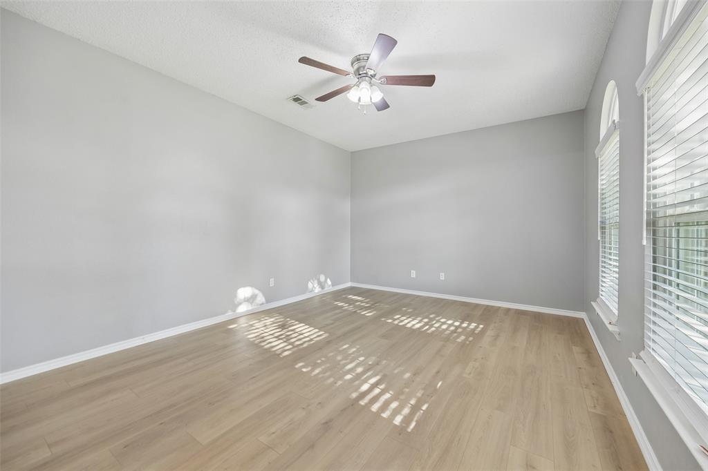 753 Summerfield Drive Allen, TX 75002 - Photo 19 of 40 Spacious room featuring wood-finish flooring, light grey walls, white baseboards, and a ceiling fan with integrated lighting