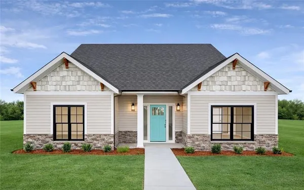 a front view of a house with a yard and garden