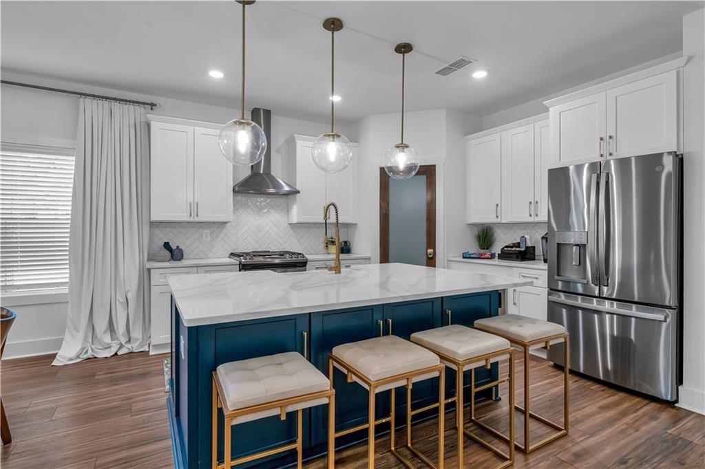 50 Puckett Road Emerson, GA 30137 - Photo 13 of 26 a kitchen with stainless steel appliances granite countertop a sink a stove a refrigerator and island with wooden floor