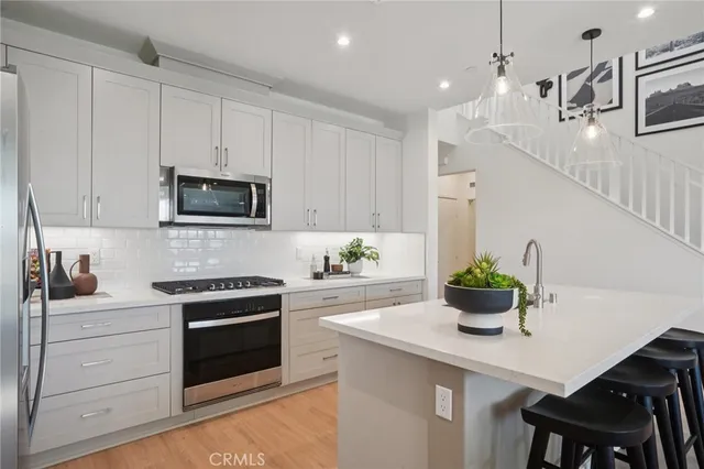 a kitchen with white cabinets and stainless steel appliances