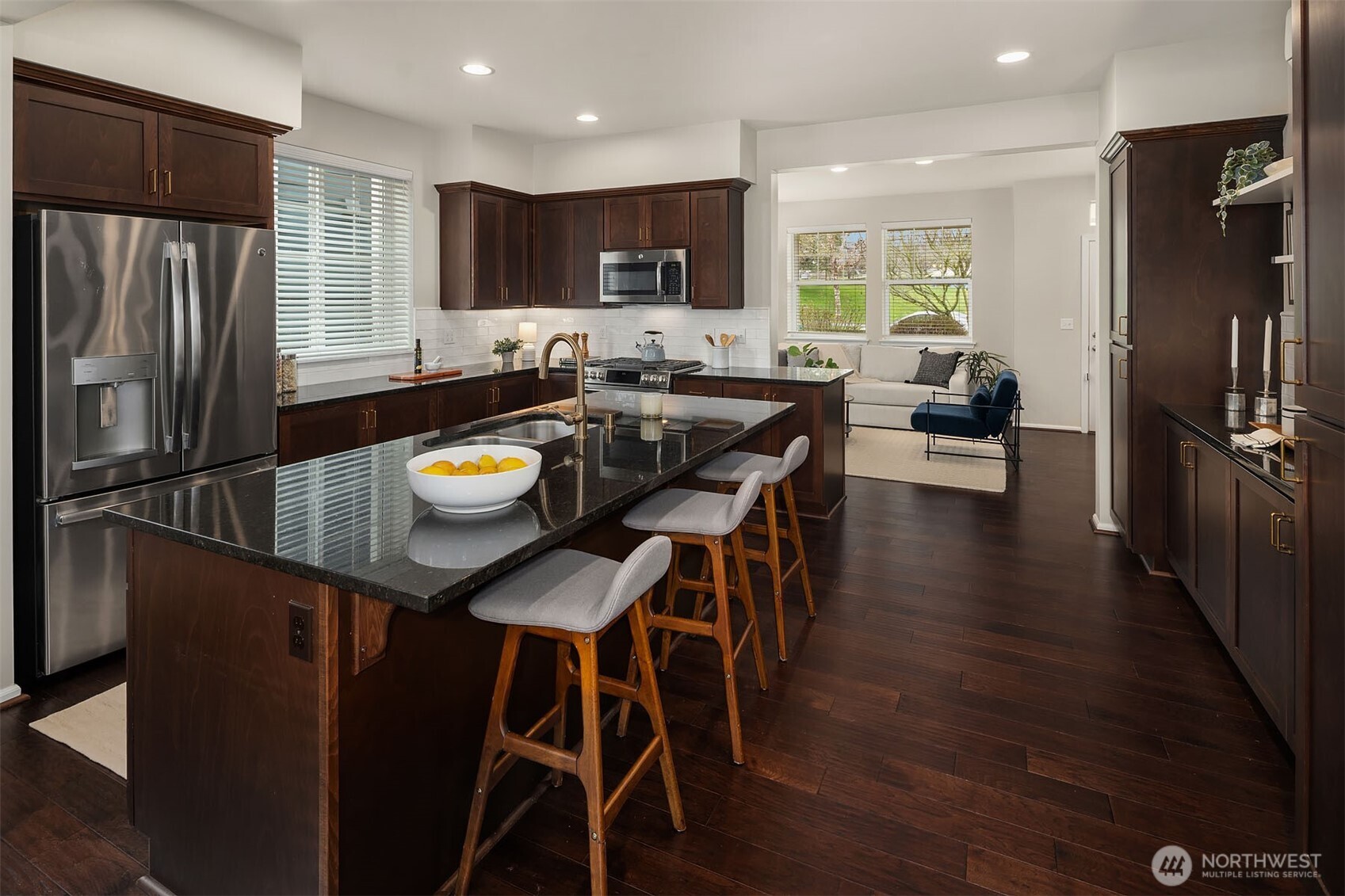6908 31st Avenue Southwest Seattle, WA 98126 - Photo 11 of 33 a kitchen with stainless steel appliances granite countertop a refrigerator a stove a sink a dining table and chairs with wooden floor