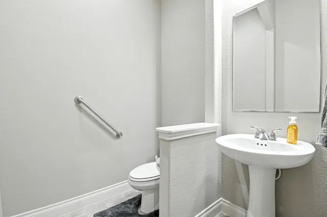 a bathroom with a sink a toilet and mirror