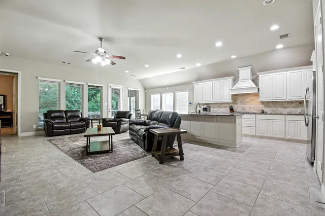 a living room with furniture and a open kitchen view