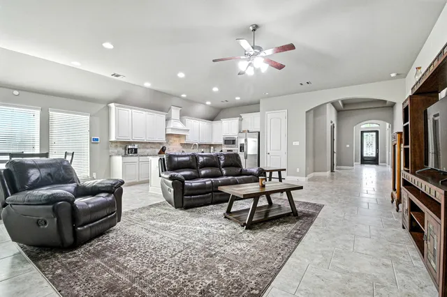 a living room with furniture and kitchen view