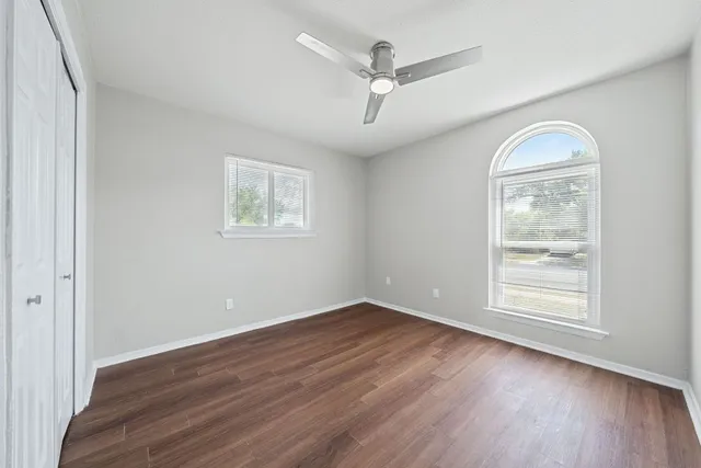 a view of an empty room with wooden floor